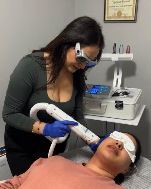 Vicky treating a client with the Aerolase laser, both in protective eyewear